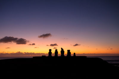 Silhouette people on beach at sunset