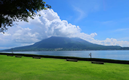 Scenic view of land by lake against sky