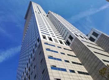 Low angle view of modern building against blue sky