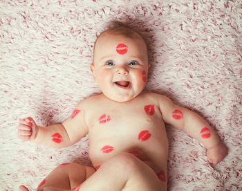 Portrait of cute baby girl lying on bed