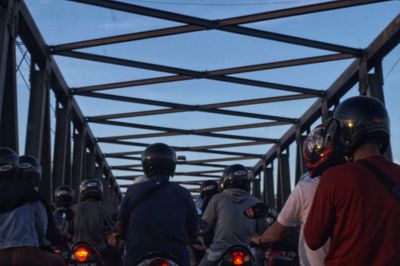 Rear view of people walking on road against sky