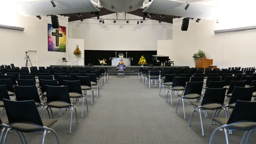 Rear view of people sitting in empty chairs