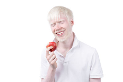 Mid adult man holding apple against white background