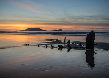 Scenic view of beach against sky during sunset