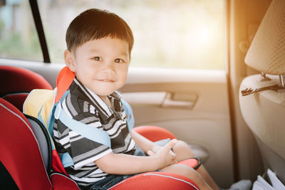 Portrait of cute boy sitting in car