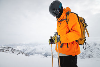 Portrait of a young adult in a ski helmet and goggles, with high