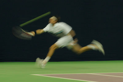Blurred motion of woman playing tennis