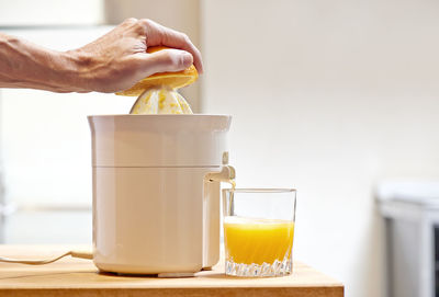 Close-up of hand making juice using fruit