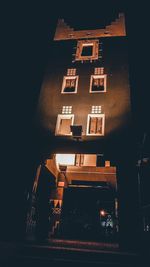 Low angle view of illuminated building against sky at night