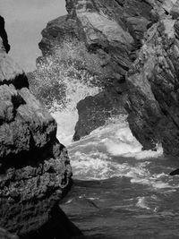 Rock formation in sea against sky