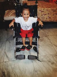 Portrait of cute boy sitting on floor