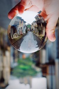 Close-up of hand holding cityscape