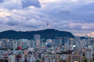 Buildings in city against cloudy sky