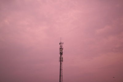 Low angle view of electricity pylon against sky during sunset