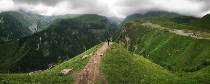 Hikers on footpath against mountains