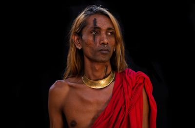 Man wearing toga against black background