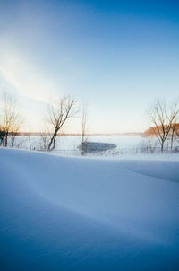 Scenic view of frozen landscape against blue sky