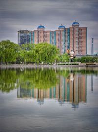 Reflection of buildings in lake against sky