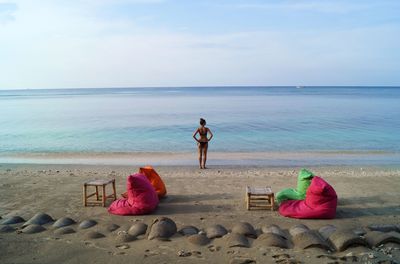 Rear view of women on beach against sky