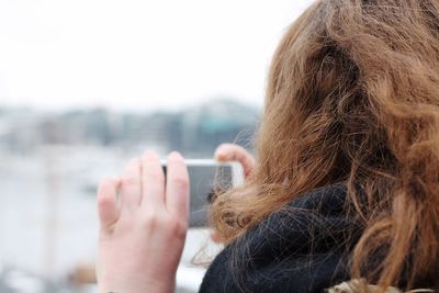 Close-up of woman using mobile phone in city