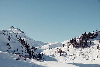 Scenic view of snowcapped mountains against clear blue sky