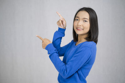 Portrait of a smiling young woman against white background