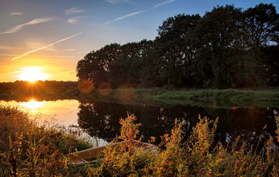 Scenic view of lake against sky at sunset