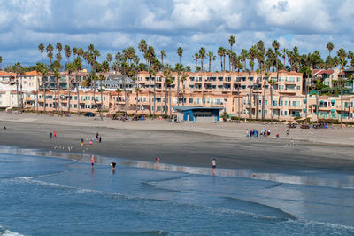 Group of people on beach against buildings in city