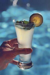 Close-up of hand holding glass of mojito