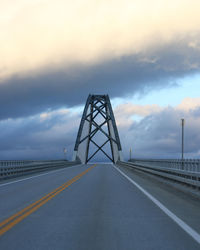 Road by bridge against sky during sunset