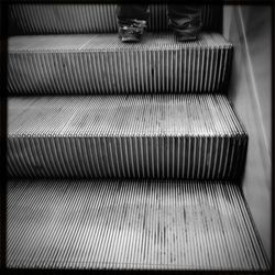 Woman standing on escalator