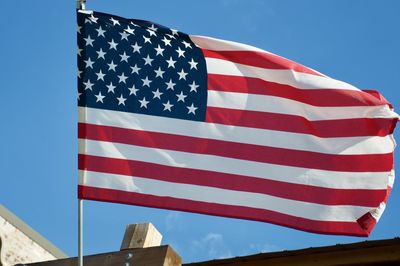 Low angle view of flag against blue sky