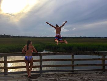 Full length of man jumping on field against sky