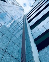 Low angle view of modern glass building against sky