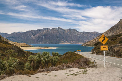 Empty road against lake and mountain