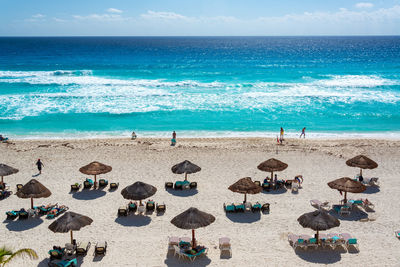 Panoramic view of people on beach against sky