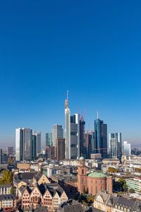 Buildings in city against blue sky