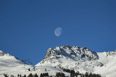 Scenic view of snowcapped mountains against clear blue sky