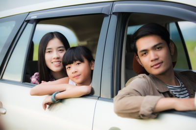 Portrait of family seen through car windows