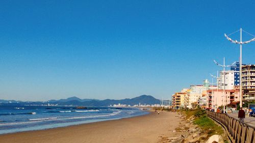 View of beach against clear blue sky