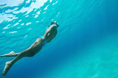 Full length of shirtless man swimming in sea