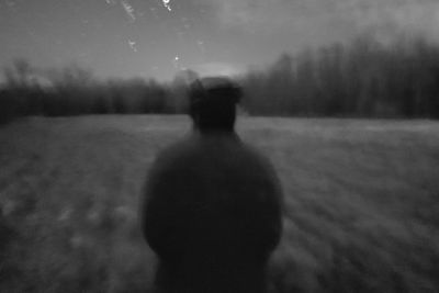 Rear view of silhouette man standing on field