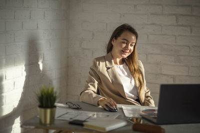 Young woman calculating success, hands-on strategies for office productivity amidst diagrams