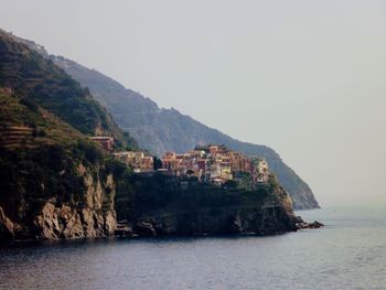 Scenic view of sea and mountains against clear sky