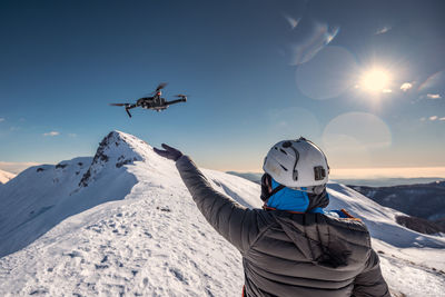 Rear view of people on snowcapped mountains against sky