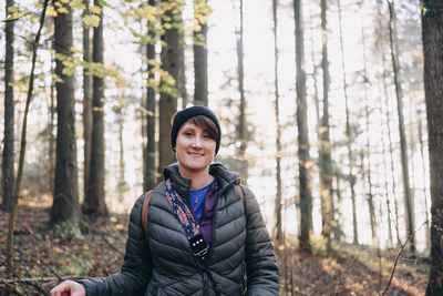 Portrait of smiling young woman in forest