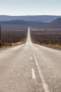 Road leading towards mountain against sky