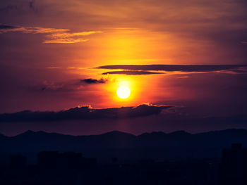 The orange sun and dark clouds over the city.