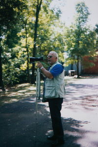 Senior man photographing on street