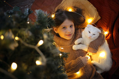 Cat and a girl under the christmas tree in a christmas atmosphere, the concept of christmas 